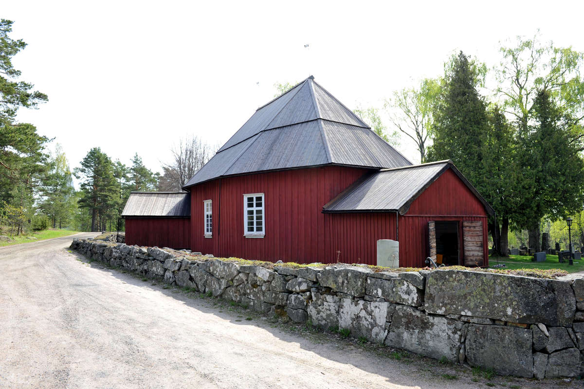 Västanfjärds gamla kyrka som är omgiven av en stenmur.